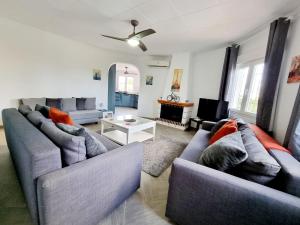 a living room with two blue couches and a tv at Charming Villa With Own Pool Urb La Siesta in La Mata