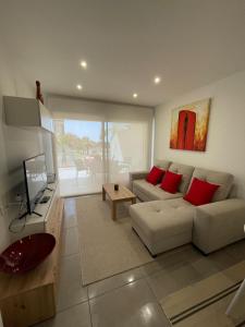 ein Wohnzimmer mit einem weißen Sofa und roten Kissen in der Unterkunft Valentino Golf II Villamartin in Villamartin