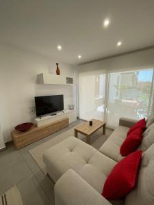ein Wohnzimmer mit einem Sofa und einem Flachbild-TV in der Unterkunft Valentino Golf II Villamartin in Villamartin