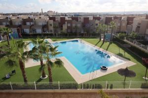 una vista aérea de una piscina con palmeras y edificios en Apto Atico Aguas Nuevas Torrevieja, en Torrevieja