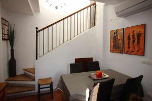a dining room with a table and a staircase at Punta Marina Green Paradise in Torrevieja