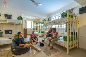 un groupe de personnes assises dans une pièce avec des lits superposés dans l'établissement Zostel Bangalore (Koramangala), à Bangalore