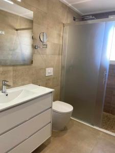 een badkamer met een toilet, een wastafel en een douche bij Duplex campoamor heated pool in Campoamor