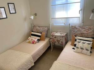 ein Zimmer mit zwei Betten und einem Tisch und einem Fenster in der Unterkunft Duplex campoamor heated pool in Dehesa de Campoamor
