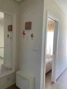 ein weißes Zimmer mit einem Bett und einem Spiegel in der Unterkunft Duplex campoamor heated pool in Dehesa de Campoamor