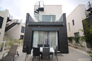 a dining area with a table and chairs in front of a building at Villa Tindra in Torrevieja