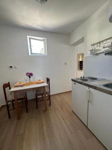 eine Küche mit einem Tisch und einem Tisch sowie eine Küche mit einem sidx sidx sidx sidx in der Unterkunft Morosini Apartments in Biograd na Moru