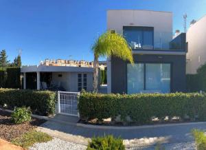 a house with a palm tree in front of it at Villa Tindra in Torrevieja