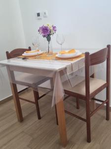 een eettafel met glazen en bloemen erop bij Morosini Apartments in Biograd na Moru