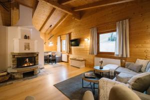 a living room with a couch and a fireplace at Steinnock Chalet in Bad Kleinkirchheim