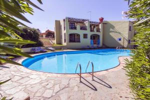 a swimming pool in front of a house at Villas with air conditioning and shared pool, just a few minutes from La Pelosa beach in Cuile Pazzoni