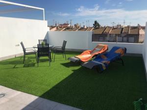 a patio with chairs and a table and grass at Apartamento Lopagan Entremares in Lo Pagán