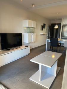 a living room with a white table and a large screen tv at la mata aqua nature in La Mata