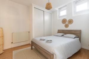 1 dormitorio con 1 cama con sábanas blancas y ventanas en SmartStay coeur de Vienne, en Vienne