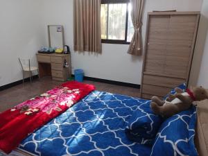 ein Schlafzimmer mit einem Bett mit einem Teddybär drauf in der Unterkunft 988 Ancient House B&B in Jincheng