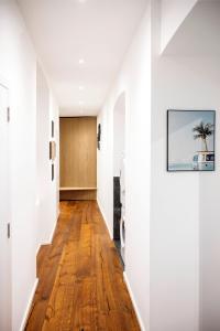 a hallway with white walls and wood floors and a painting on the wall at Komfortable Wohnung Schönbrunn in Vienna