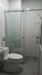 y baño con aseo y ducha acristalada. en Red Bean Hotel en Thuan An