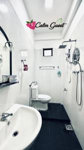 uma casa de banho branca com um lavatório e um WC em Calm Guest em Trincomalee