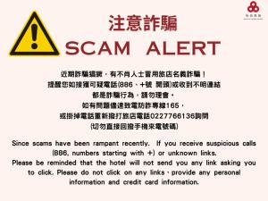 a sign that reads scam alert with a danger sign at Eastin Taipei Hotel in Taipei
