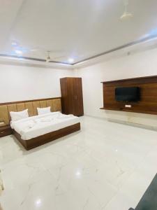 a bedroom with a bed and a flat screen tv at Bachan Niwas Hotel in Jodhpur