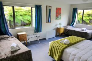 een hotelkamer met 2 bedden en 2 ramen bij Central & Relaxing in Franz Josef
