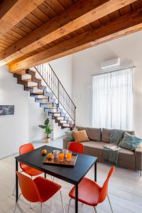 un soggiorno con tavolo nero e sedie arancioni di Open Sicily Homes "Residence Guascone" - Self check in a Palermo