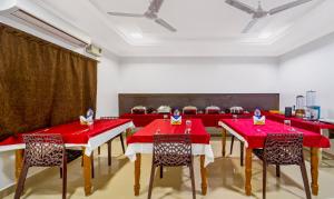 uma sala de jantar com mesas e cadeiras vermelhas em Treebo Trend NGH Transit em Chennai