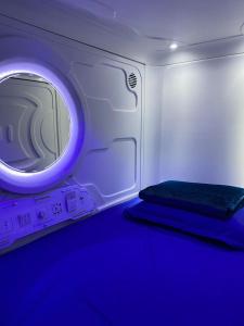 een kamer met een magnetron met een blauw licht bij Capsule Inn in Kota Kinabalu