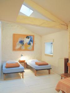 two twin beds in a room with a skylight at Hameau de la Brousse in Sers