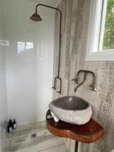 a bathroom with a stone sink on a wooden table at The Boathouse in Daleys Point
