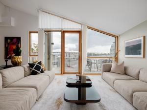 a living room with two couches and a table at Fully serviced apartment with spectacular views towards the Munch Museum in Oslo