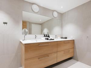 La salle de bains est pourvue d'un lavabo et d'un miroir. dans l'établissement Fully serviced apartment with spectacular views towards the Munch Museum, à Oslo