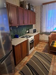 een keuken met houten kasten en een fornuis met oven bij Linte apartment 