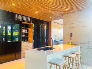 a kitchen with a sink and a counter with stools at Moon Villa Phu Quoc - 3 Bedroom - Private pool in Phu Quoc