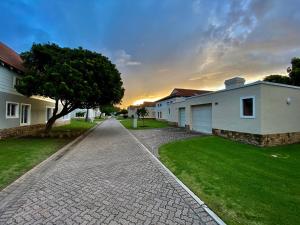 a cobblestone driveway in front of some houses at The Dunes Resort 80 & 69 in Plettenberg Bay