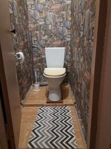 een badkamer met een toilet en een stenen muur bij Linte apartment 