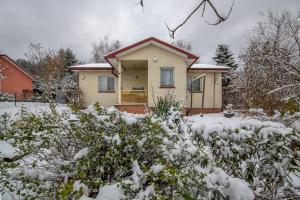 dom pokryty śniegiem w obiekcie Domek bez zegara w mieście Lądek-Zdrój