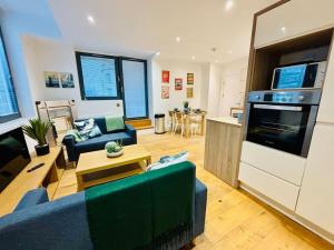 a living room with a blue couch and a kitchen at Riverside Apartment with balcony in Bristol