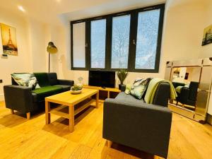 a living room with two couches and a table at Riverside Apartment with balcony in Bristol