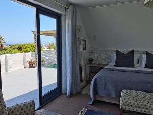 a bedroom with a bed and a sliding glass door at Vermont Lofts in Hermanus