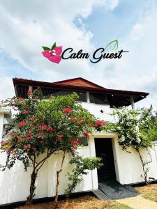 um edifício branco com um sinal de borboleta cor-de-rosa. em Calm Guest em Trincomalee
