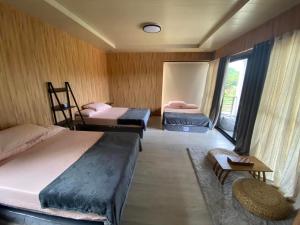 Zimmer mit 3 Betten und einem Fenster in der Unterkunft Jill’s Maison in Malawin