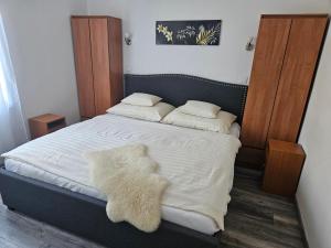 a bedroom with a bed with white sheets and pillows at Németh Apartmanok in Zalakaros