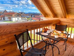 uma mesa e cadeiras na varanda de um camarote em "Allgäu-Herzl" Alpenchalet für Zwei em Rückholz