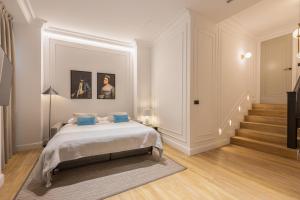 a bedroom with a bed with blue pillows at Edmond Vibes Puerta del Sol Suites in Madrid