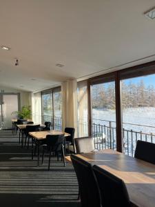 a dining room with tables and chairs and windows at Hotel Olimp in Prudnik