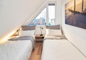 Duas camas num quarto com uma janela em Paradise Suite - Penthouse mit Meerblick em Timmendorfer Strand