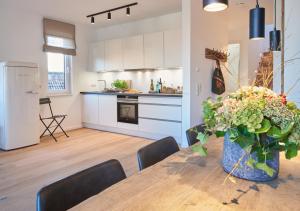 uma cozinha e uma mesa com um vaso de flores em Paradise Suite - Penthouse mit Meerblick em Timmendorfer Strand