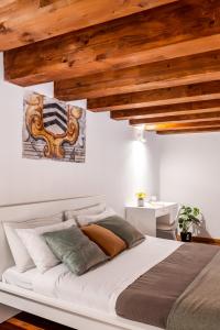 una camera da letto con un grande letto bianco e soffitti in legno di Open Sicily Homes "Residence Guascone" - Self check in a Palermo