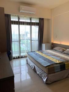 a bedroom with a bed and a large window at Emerald diamond Building 2 in Zhunan
